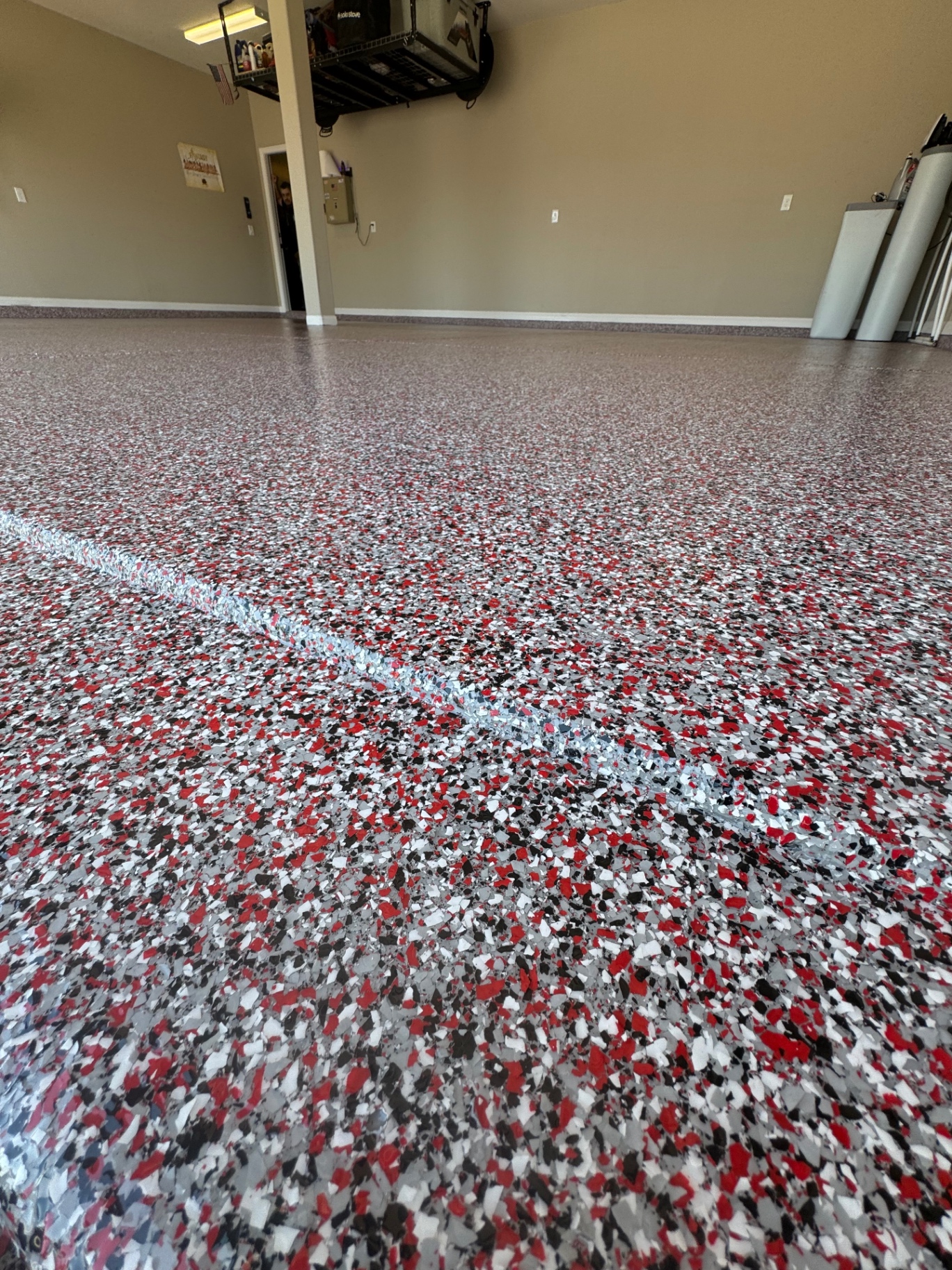 Red, gray, and black flake garage floor in a finished residential garage